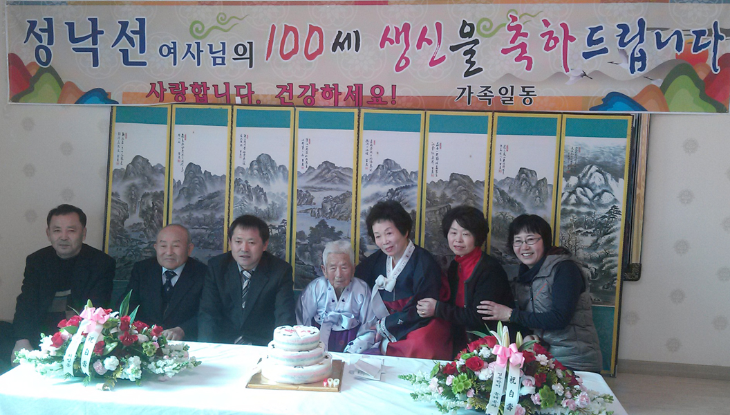 성낙선 할머니가 가족들과 100세 노인잔치를 하며 기념사진을 촬영하고 있다.