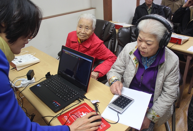 금남면 노인정에 비치된 청력재활기를 통해 한 노인이 청각 테스트를 받고 있다.