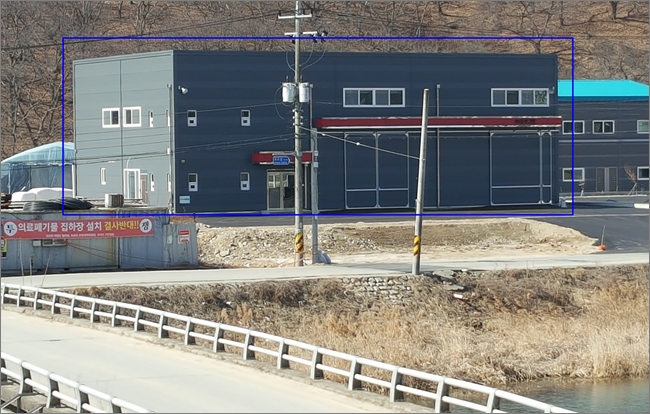 ▲논란의 중심에 선 D사 신축 건축물(파란색 실선) 좌측으로 의료폐기물 집하장 설치를 반대하는 현수막일 걸려 있다.