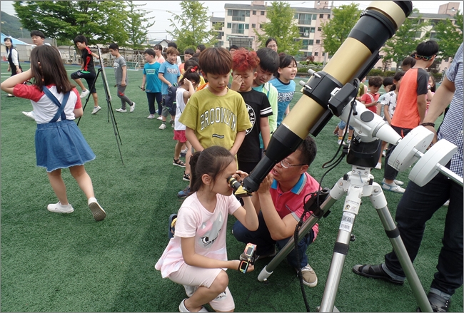 전동초 학생들이 망원경을 보는 방법을 배우고 있다.