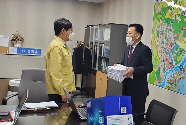 ▲김재헌 대표(왼쪽 두번째)가 세종시 김병호 대변인에게 세종시 지하철 직선화 서명부를 전달하고 있다.