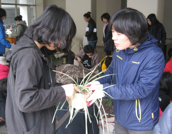  피옥자(사진 오른쪽) 농기센터 도시농업담당이 주민에게 화초관리기술을 설명하고 있다.